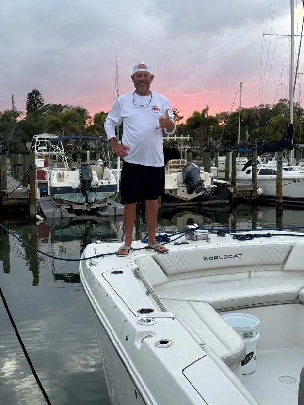 Captain Cuda on the bow of Phat Kat at the St. Pete marina under a pink sunset